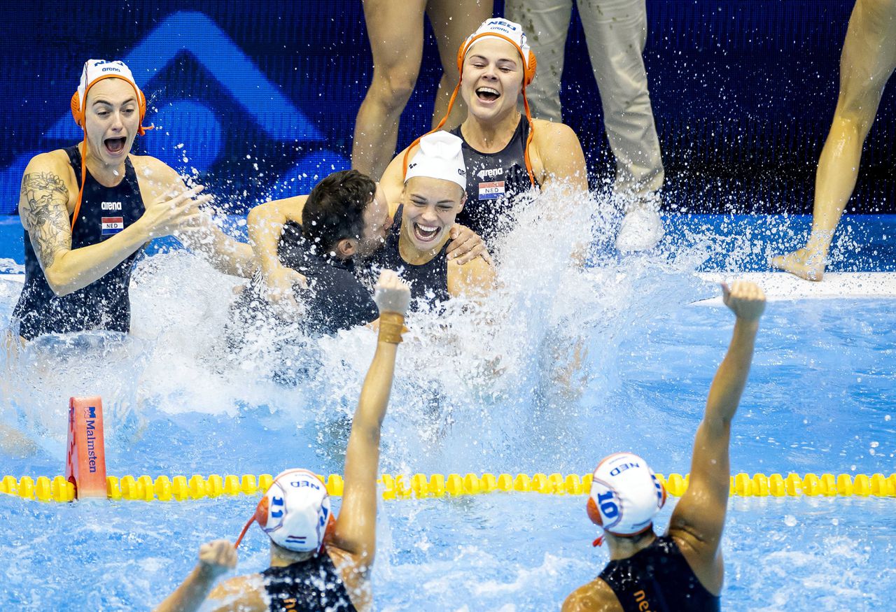 De Nederlandse waterpolosters gooien Coach Evangelos Doudesis in het water om hun wereldtitel te vieren.