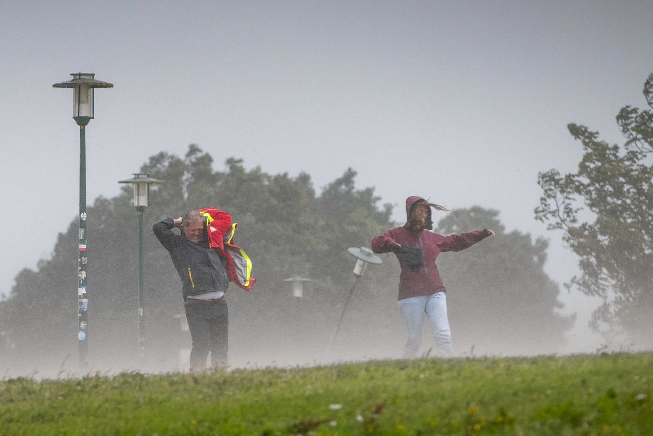 Wandelaars bij strand Lemmer, tijdens zomerstorm Poly.