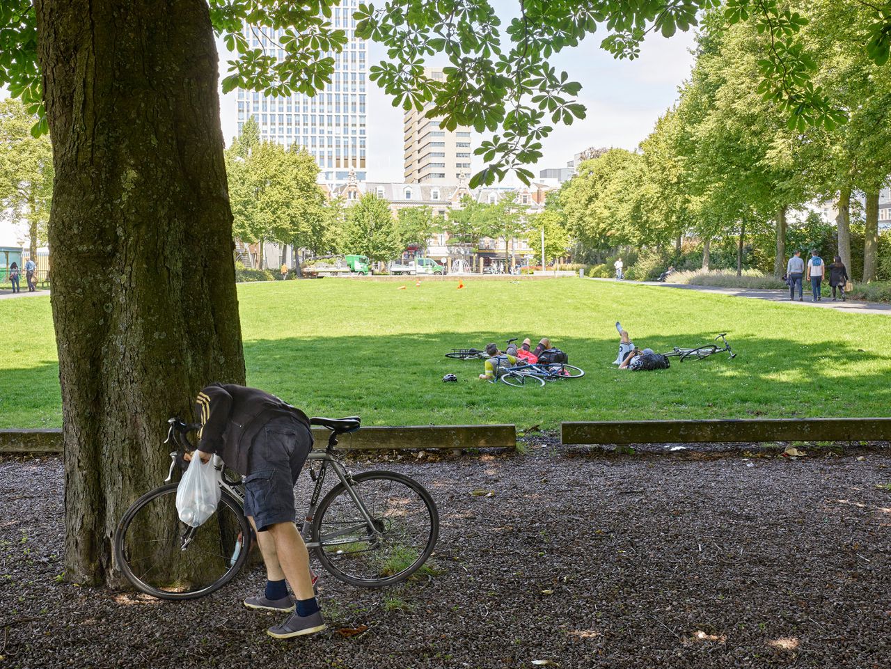 Een man verzamelt lege blikjes in het park.