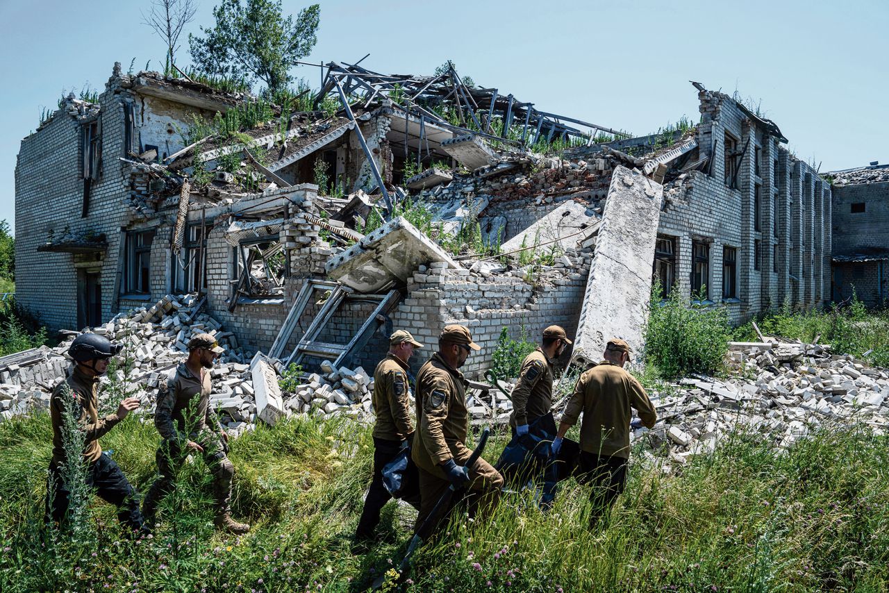 In het Oekraïense Virnopillja wordt het lichaam van een omgekomen Russische militair geborgen.