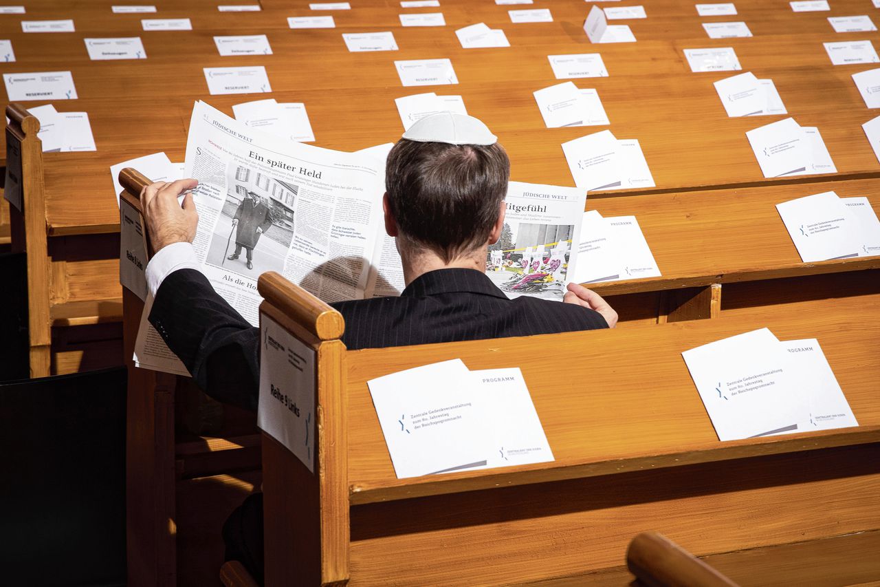 Een man leest een Joods weekblad tijdens de herdenking van de Kristallnacht in de synagoge Rykestrasse, in de Berlijnse wijk Prenzlauer Berg.