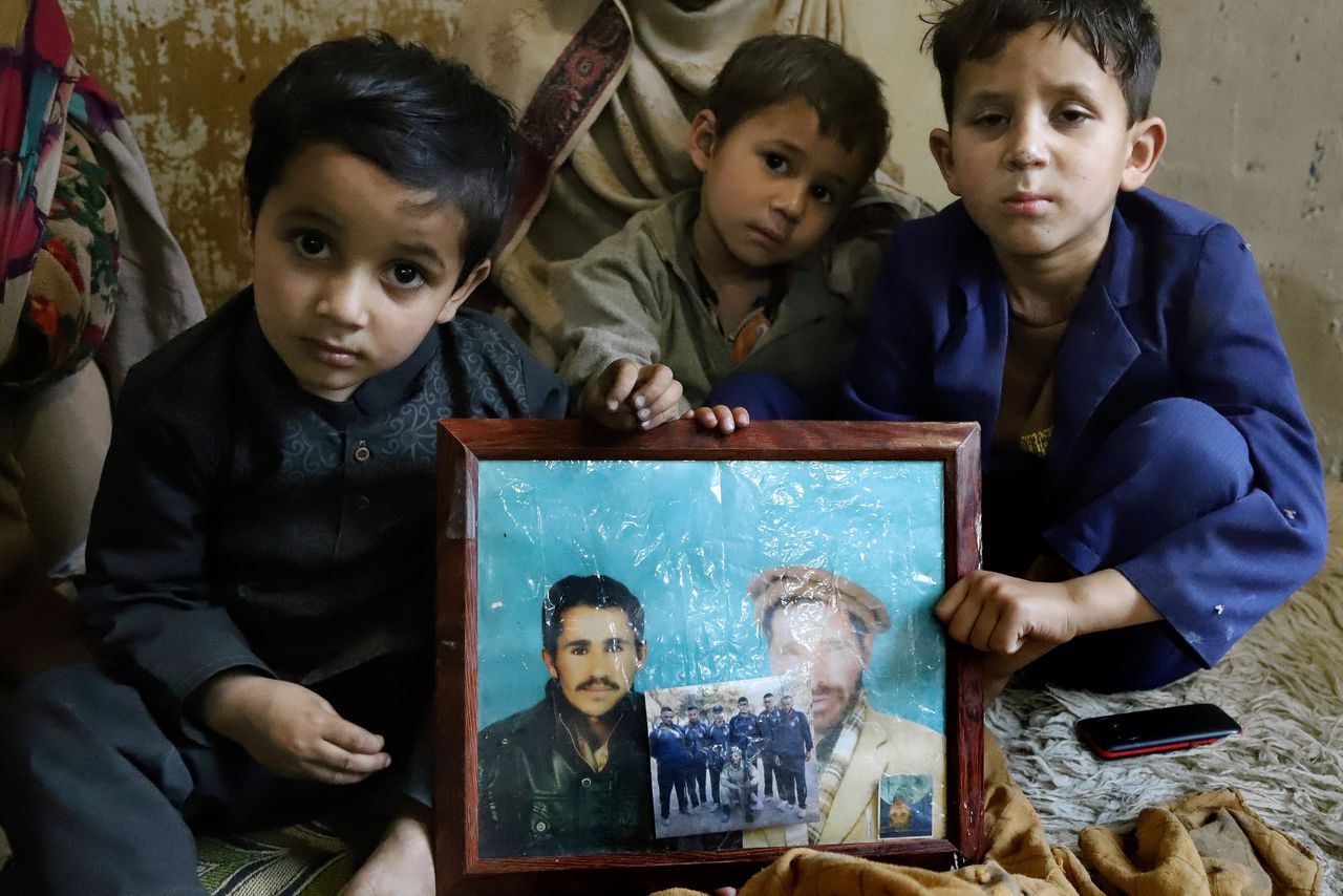 De kinderen van Mohammed Hassan met foto’s van hun vader, die overleed na een val op de berg K2.