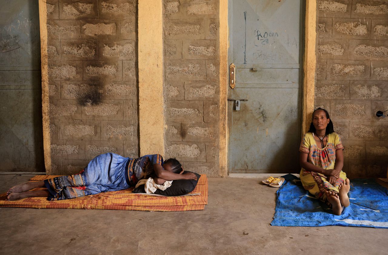 Oorlogsslachtoffers die ontheemd zijn, rusten uit buiten hun schuilplaats in de regio Tigray.