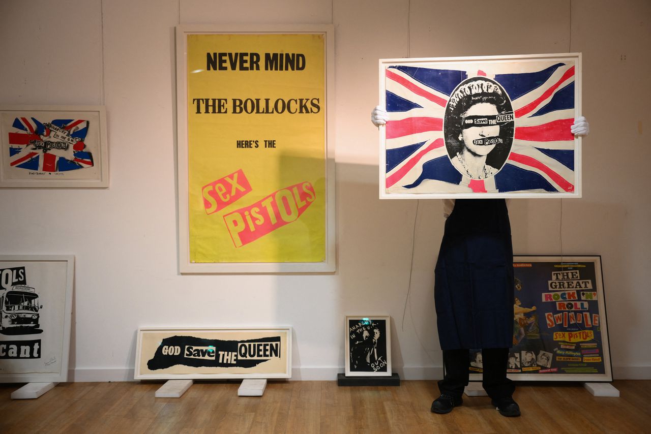 Werk van Jamie Reid: posters van ‘God Save the Queen’ en ‘Never Mind the Bollocks, Here’s The Sex Pistols’, albums van punkband The Sex Pistols.