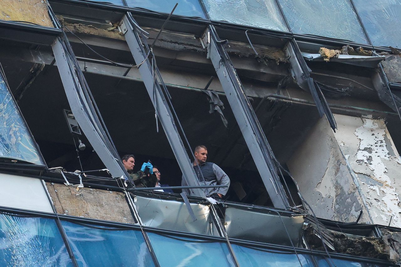 Veiligheidsfunctionarissen onderzoeken de schade aan een kantoor in het zakendistrict Moskva-City, na een drone-aanval.