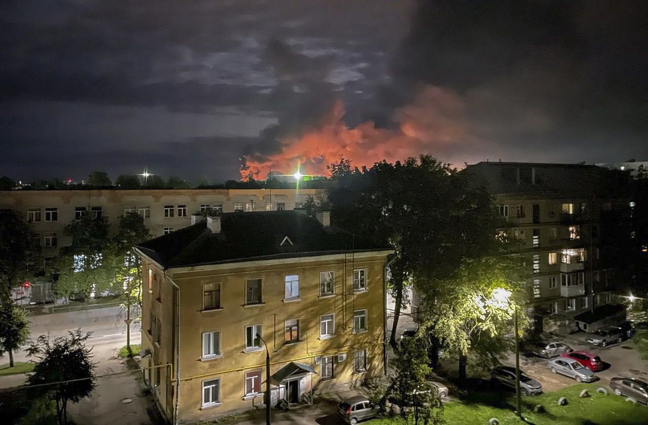 Een vlammenzee boven het vliegveld is zichtbaar vanuit de stad Pskov. Vier militaire transportvliegtuigen zouden zijn geraakt door brokstukken van drones.