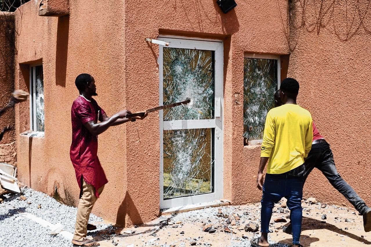 Betogers breken zondag een deur en ramen van de Franse ambassade in Niamey, de hoofdstad van Niger.