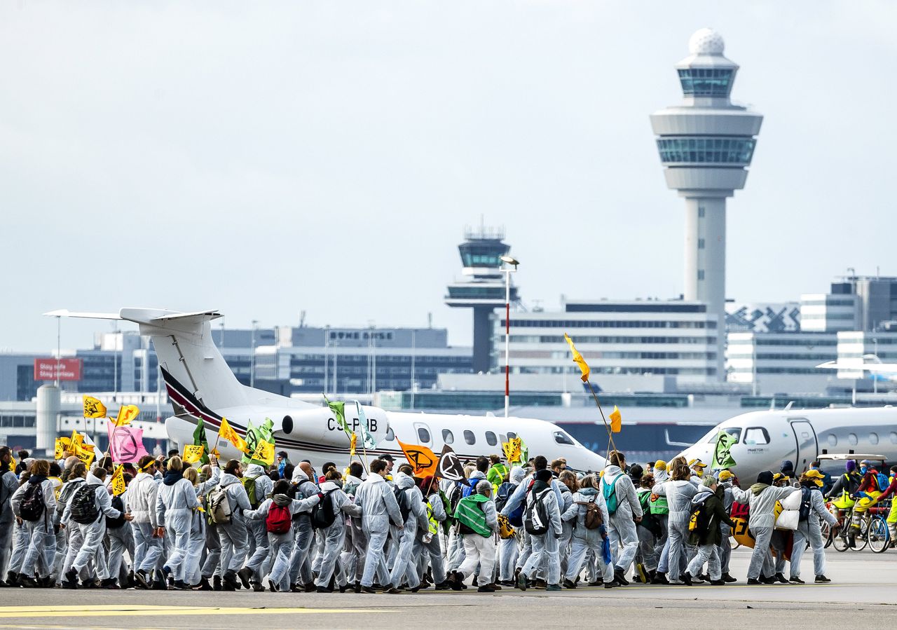 Klimaatactivisten op luchthaven Schiphol bij privé-vliegtuigen. Vierhonderd mensen werden aangehouden bij de actie.