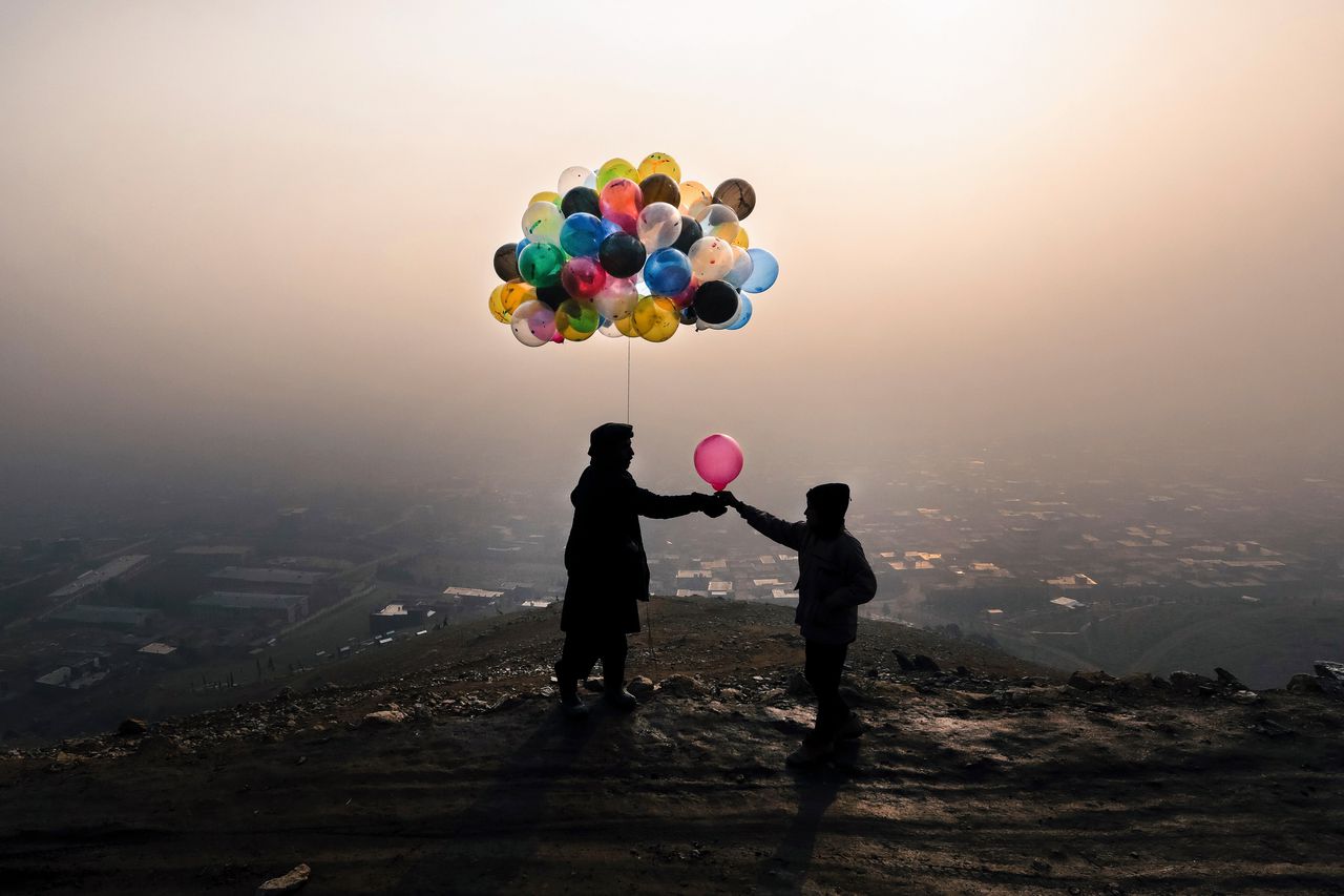 December 2020. Een Afghaanse man verkoopt een ballon op een heuvel in een buitenwijk van Kabul.