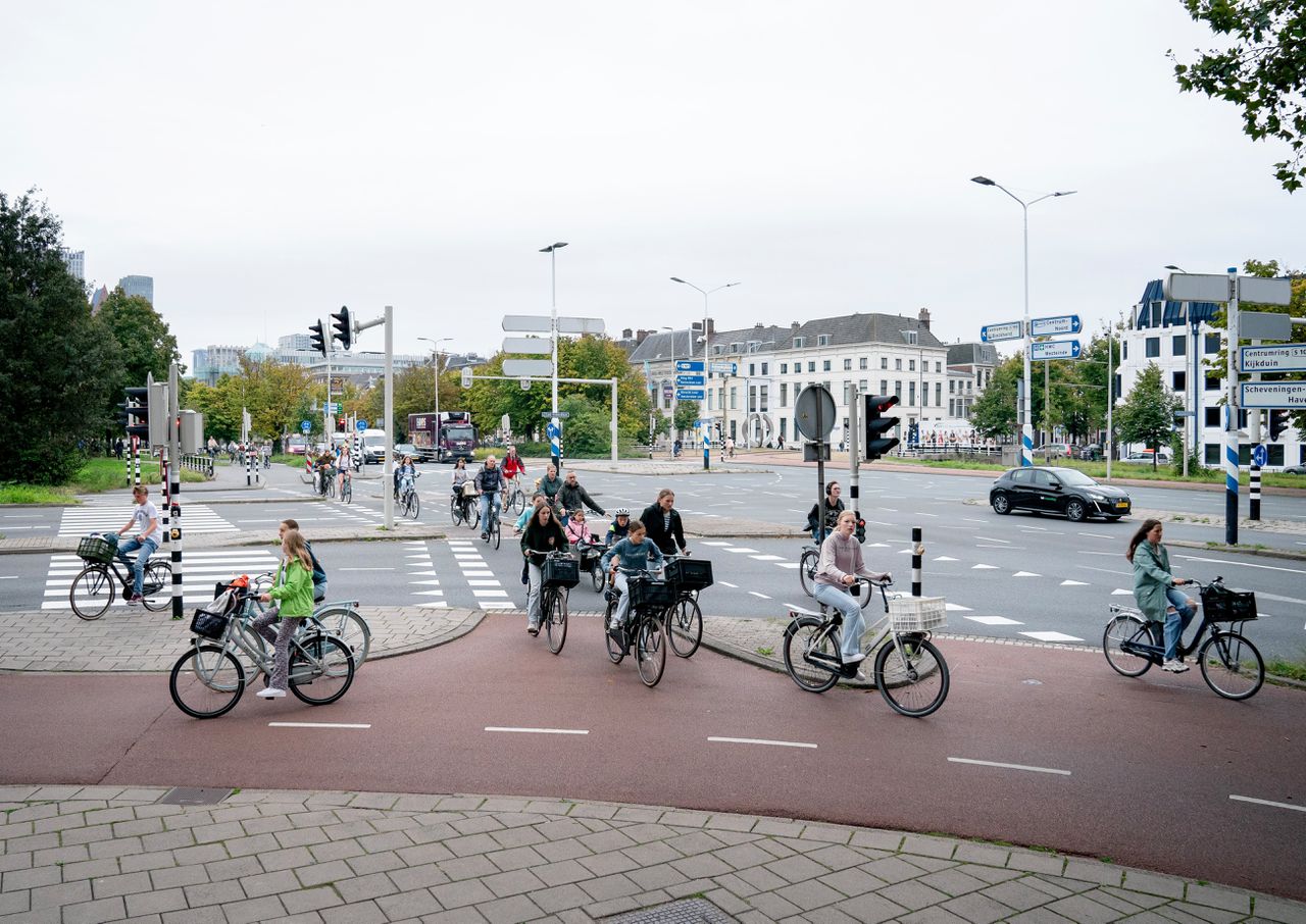 Fietsers op het fietspad op het kruispunt van de Zuid-Hollandlaan en de Koningskade, in het centrum van Den Haag.