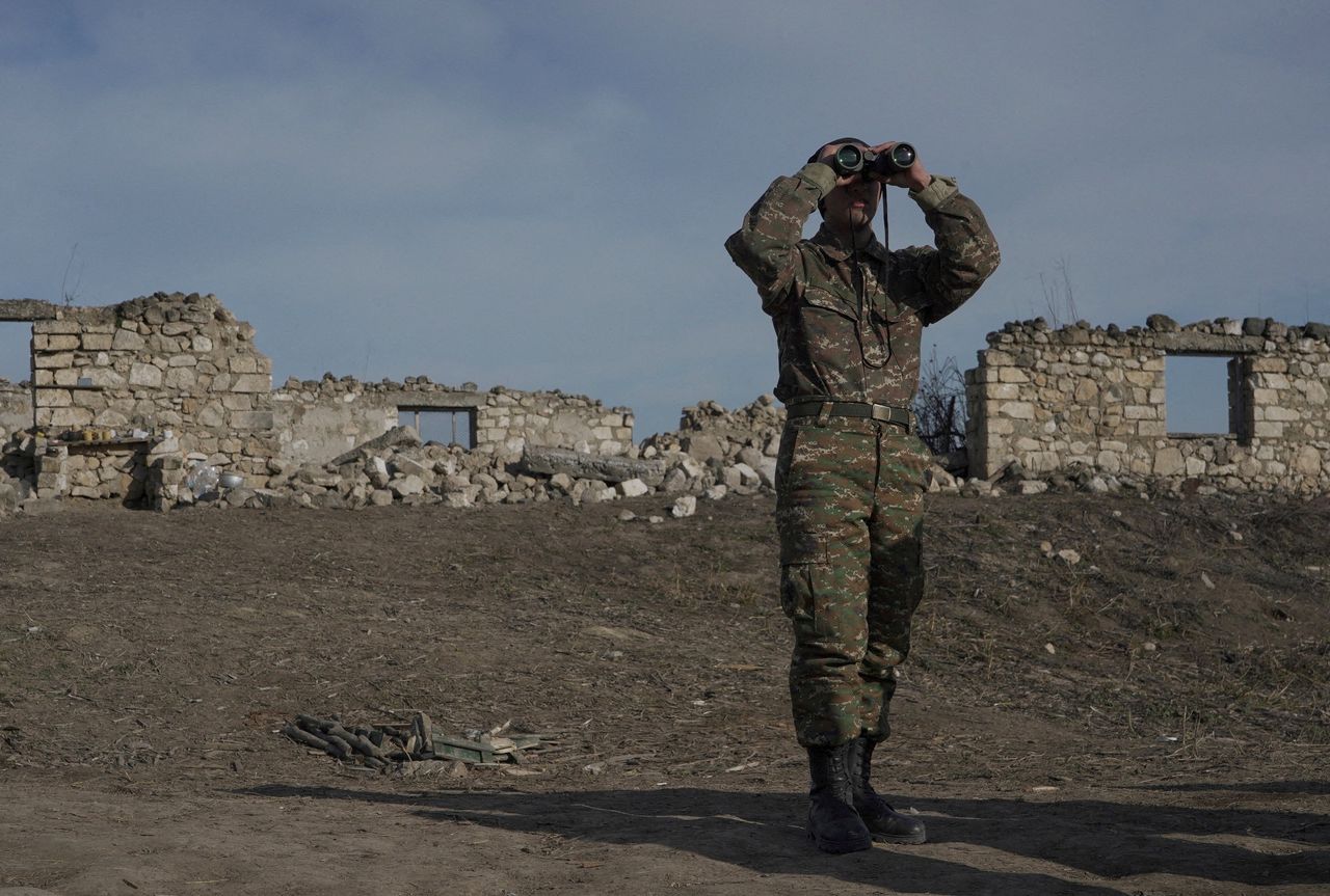 Een Armeense soldaat kijkt door een verrekijker naar de regio Nagorno-Karabach in januari 2021.