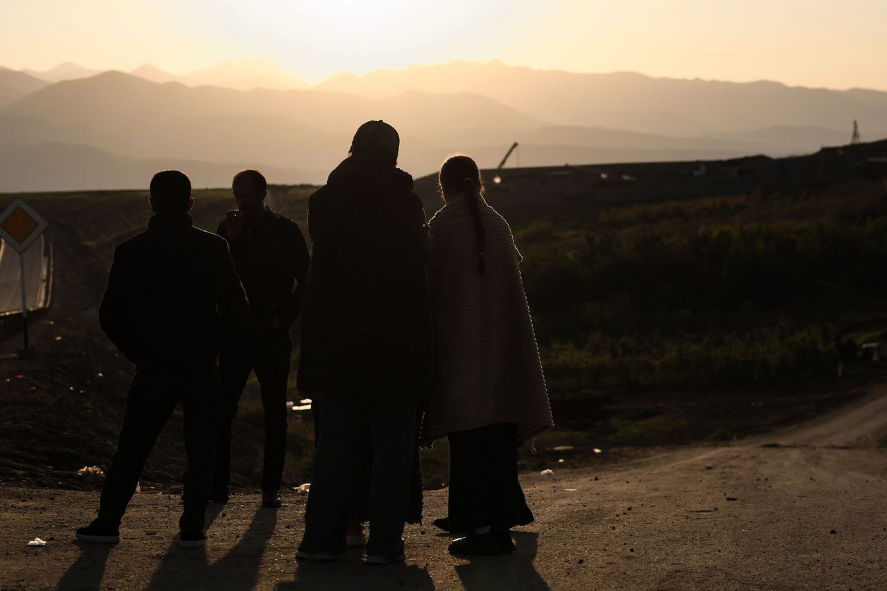 Vluchtelingen uit Nagorno-Karabach staan langs de weg met zicht op het Karabach-gebergte nadat ze de Armeense grens van de enclave zijn overgestoken.