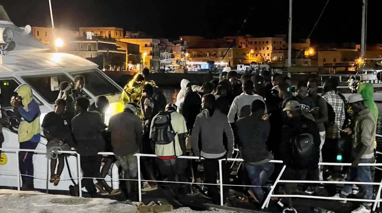 Migranten op een Frontex-patrouilleboot aan een kade op Lampedusa.