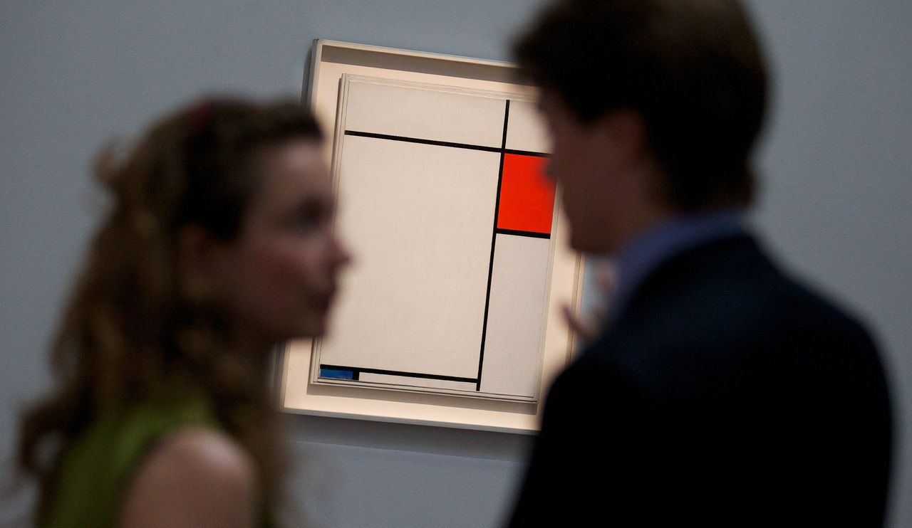 Twee bezoekers kijken naar 'Composition with red, blue and grey' van Piet Mondriaan op een veiling in Londen in 2014.