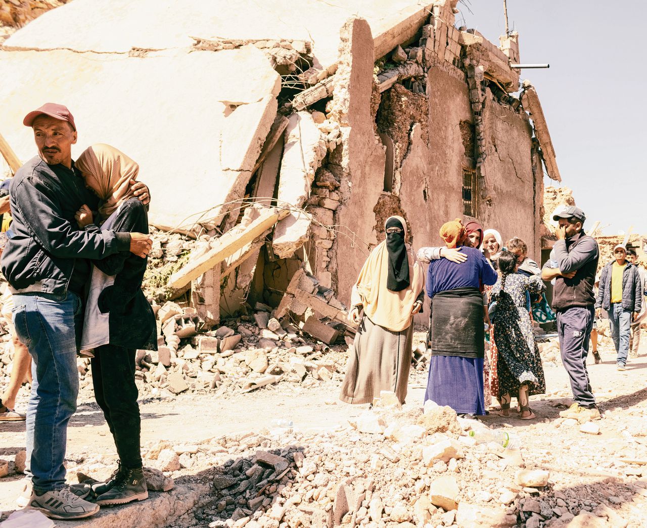 Inwoners van het dorp Anougal, ongeveer honderd kilometer ten zuiden van Marrakech, rouwen tussen verwoeste huizen, na de zware aardbeving die het gebied vrijdag trof.