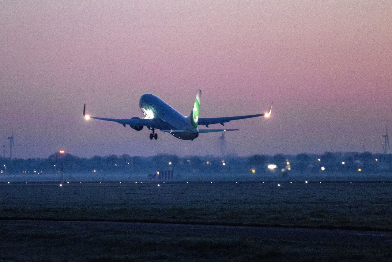 Een vliegtuig van Transavia stijgt op vanaf Schiphol. De luchthaven wil alle nachtvluchten schrappen om de geluidsoverlast te beperken.