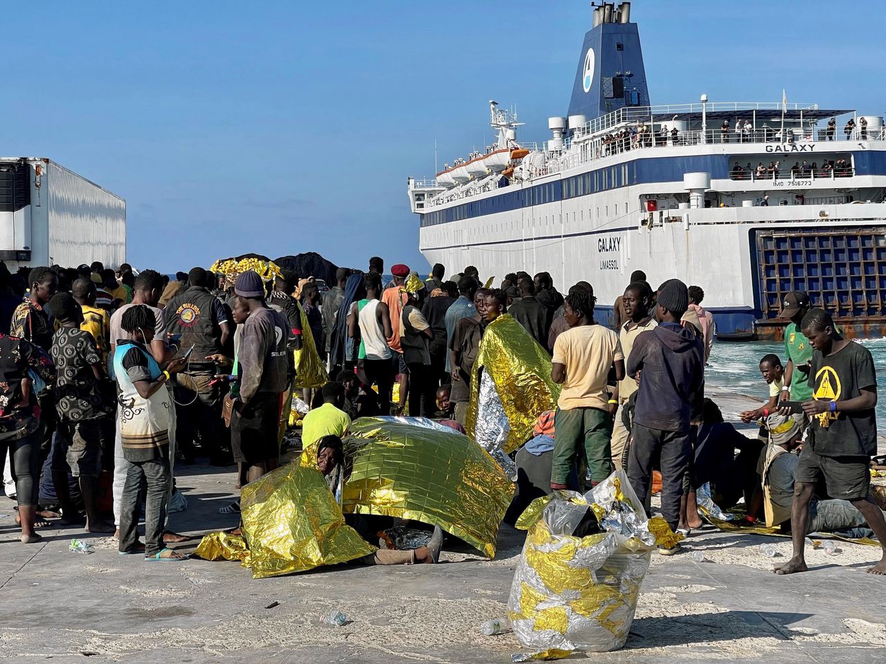 Een groep migranten op Lampedusa wacht tot ze naar het vasteland worden gebracht.