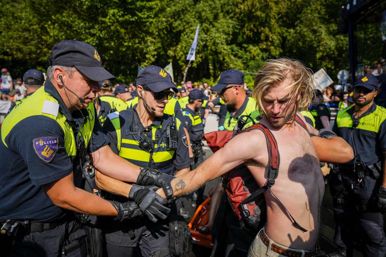 De politie begint met het weghalen van klimaatactivisten van Extinction Rebellion die de Utrechtsebaan op de A12 in Den Haag blokkeren.