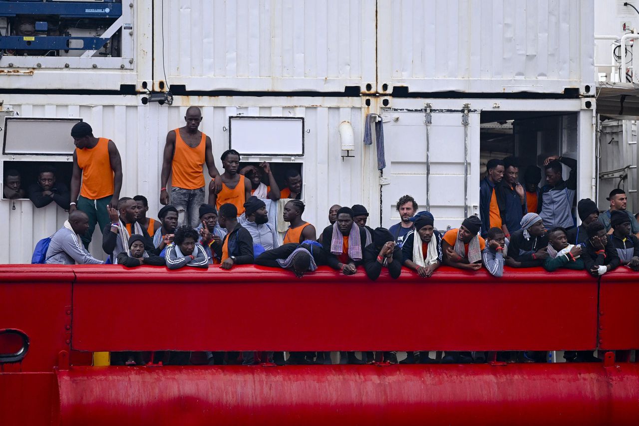 Migranten aan boord van het SOS Mediterranee schip ‘Ocean Vikiing’, dat hen uit zee oppikte, arriveren eind augustus in Napels.