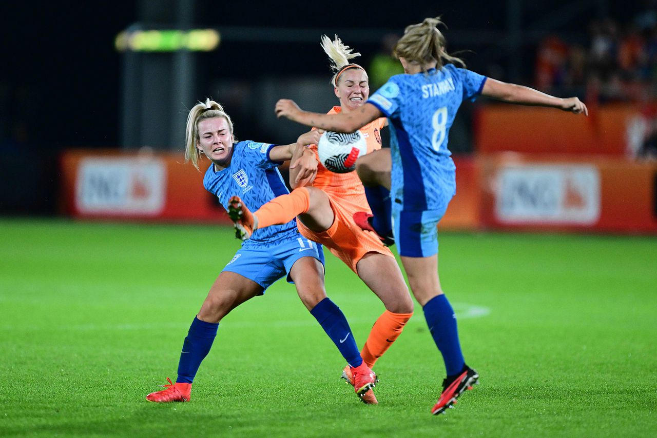 Middenvelder Jackie Groenen wordt op het middenveld belaagd door Lauren Hemp en Georgia Stanway van Engeland.