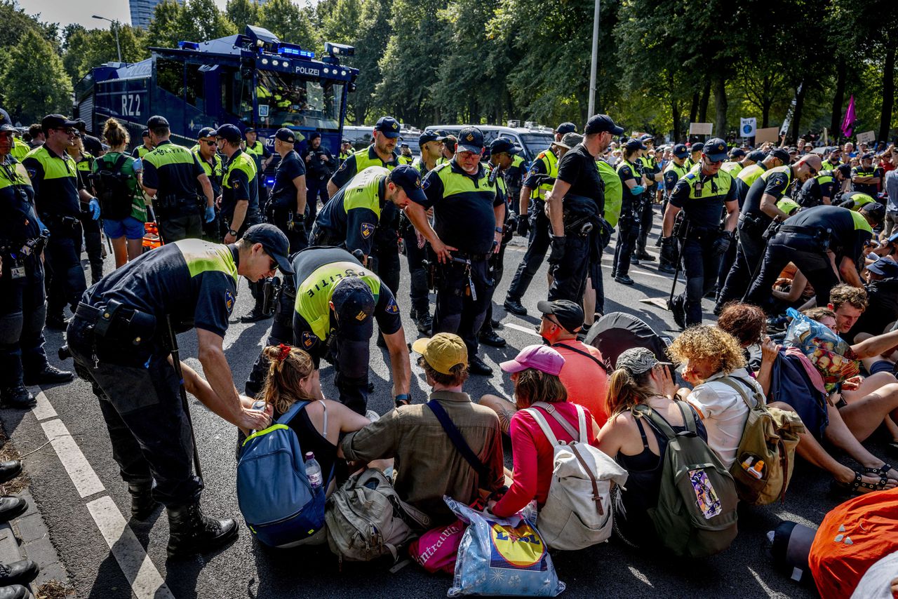 De politie treedt op tegen klimaatactivisten op het wegdek van de A12.