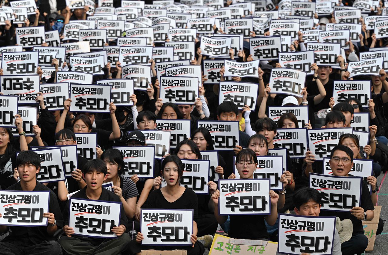 Demonstranten in Seoul houden spandoeken omhoog met de tekst: "De waarheid onthullen is de manier om respect te tonen".