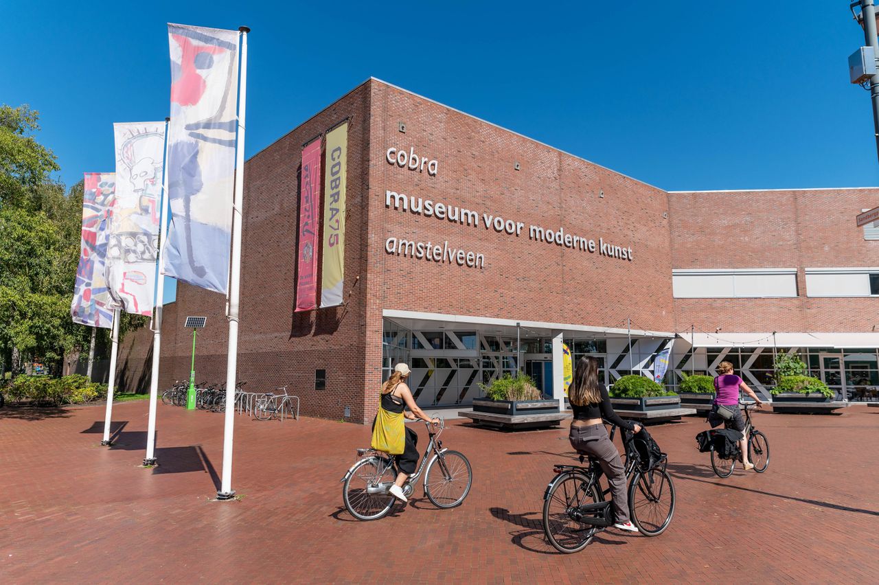 Mensen fietsen langs het Cobra Museum