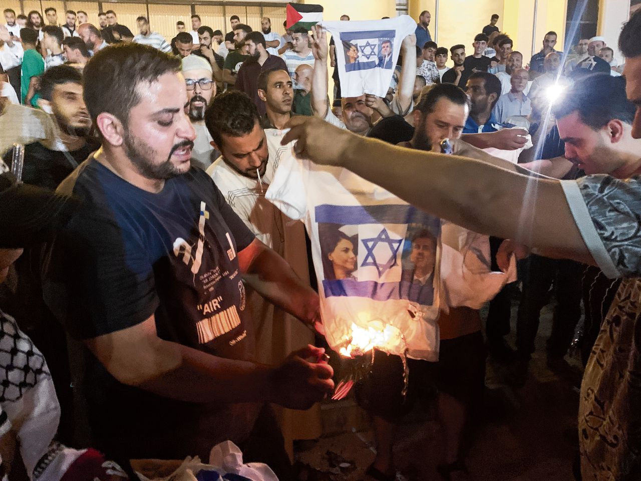 Betogers steken een T-shirt in brand bij protesten in de Libische hoofdstad Tripoli op 27 augustus, na de ontmoeting tussen de Libische minister van Buitenlandse Zaken Najla al-Mangoush en haar Israëlische ambtgenoot Eli Cohen in Rome.