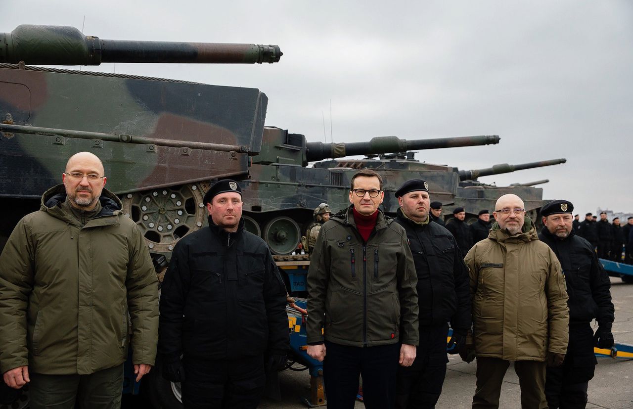 De Poolse premier Mateusz Morawiecki (derde van links) en premier Denys Shmyhal (links) en toenmalig Defensieminister Oleksii Reznikov (tweede van rechts) van Oekraïne bij de levering van de eerste lichting Poolse Leopard 2-tanks aan Oekraïne, februari 2023.