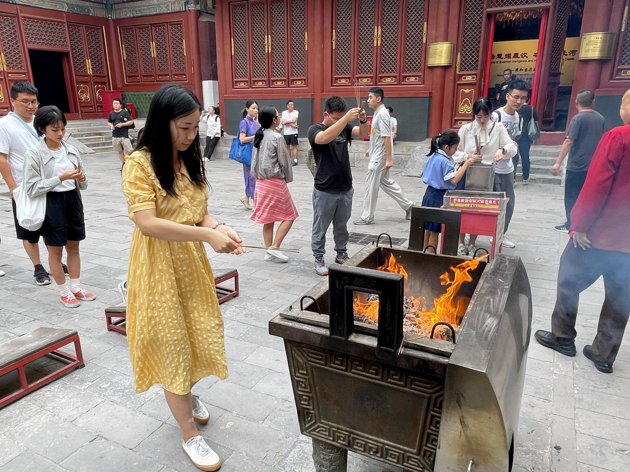 Wang Zubei (24) brandt wierookstokjes in een Lamatempel in Beijing. Ze hoopt op meer geld, een goede gezondheid en „een mooi liefdesleven”.