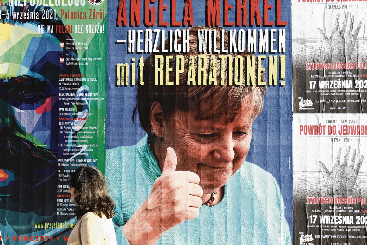 Affiche met oud-kanselier Angela Merkel en een oproep tot herstelbetalingen wegens oorlogsleed in Warschau in 2021.