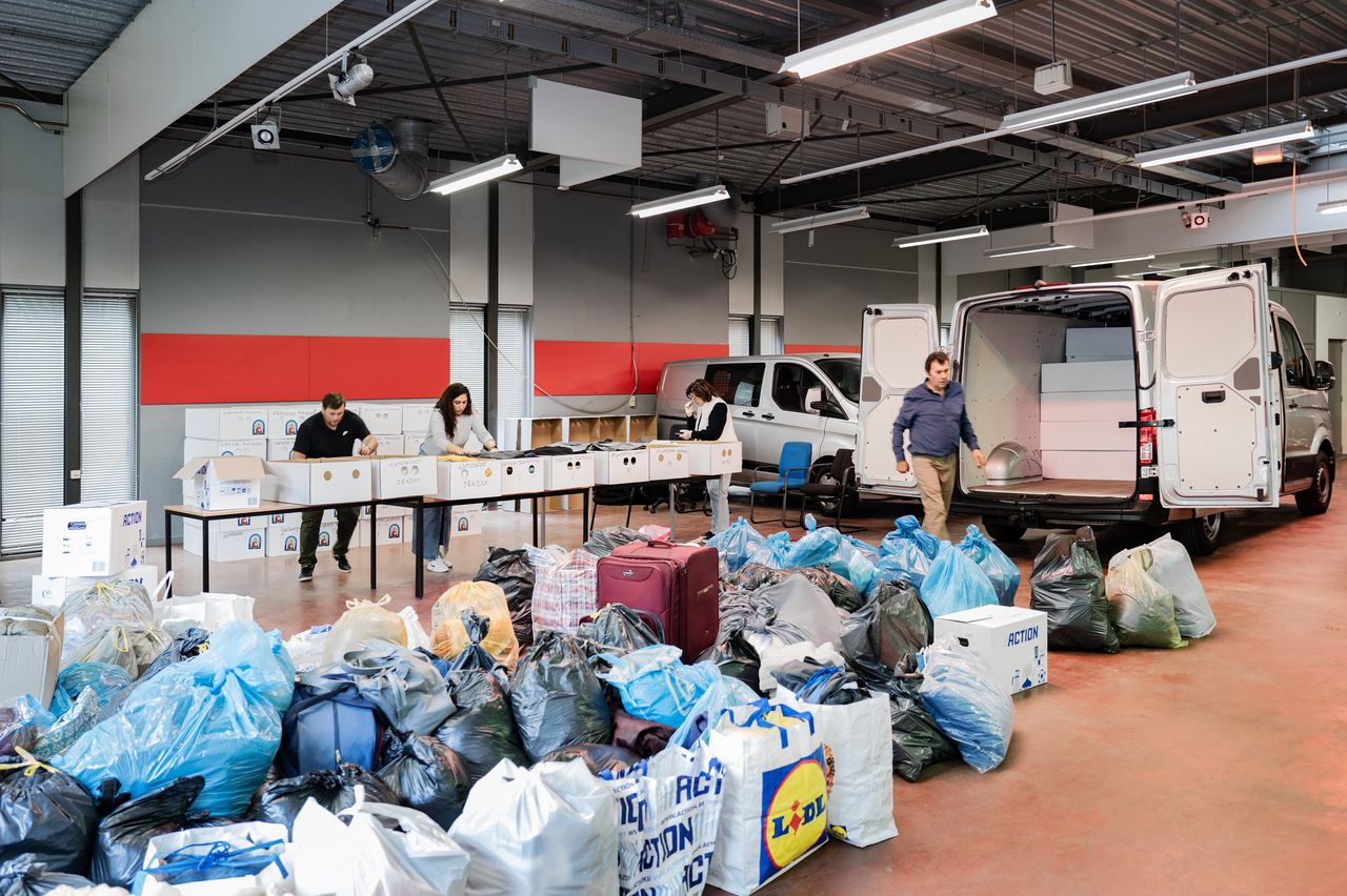 In een bedrijfsloods in Mijdrecht vullen vrijwilligers dozen met hulpgoederen voor transport naar de Armeense hoofdstad Jerevan.