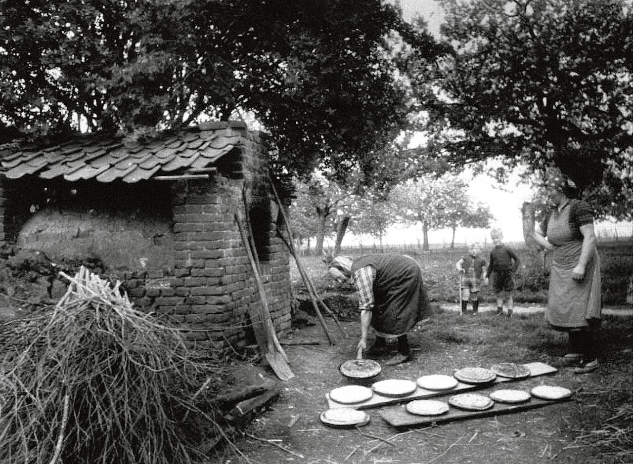 Limburgse vlaaien werden vroeger in dorpen meestal gebakken in het ‘bakkes’ of ‘bakhoes’, een gemetselde oven die los van de woning stond. Zoals hier in Susteren, in de jaren vijftig.