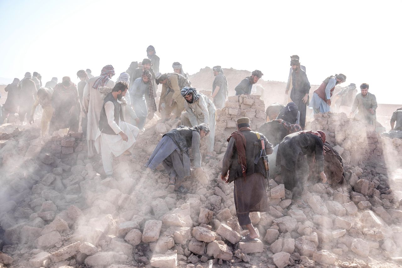 Hulpverleners tussen het puin in het district Zenda Jan in de Afghaanse provincie Herat. De verwoesting is groot nu de regio in enkele dagen tijd door twee zware aardbevingen werd getroffen.