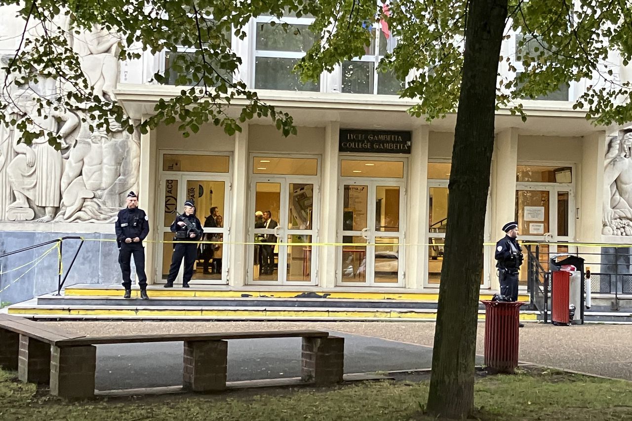 Politieagenten staan voor de middelbare school waar vrijdag een docent werd doodgestoken door een oud-leerling.