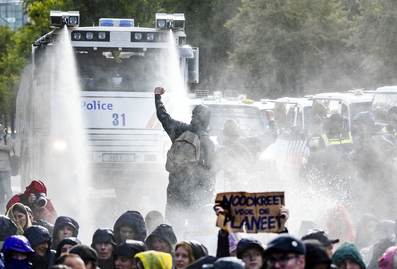 De politie zet een waterwerper in tegen klimaatdemonstranten die wederom actie voeren op en rond de A12 bij het Malieveld.