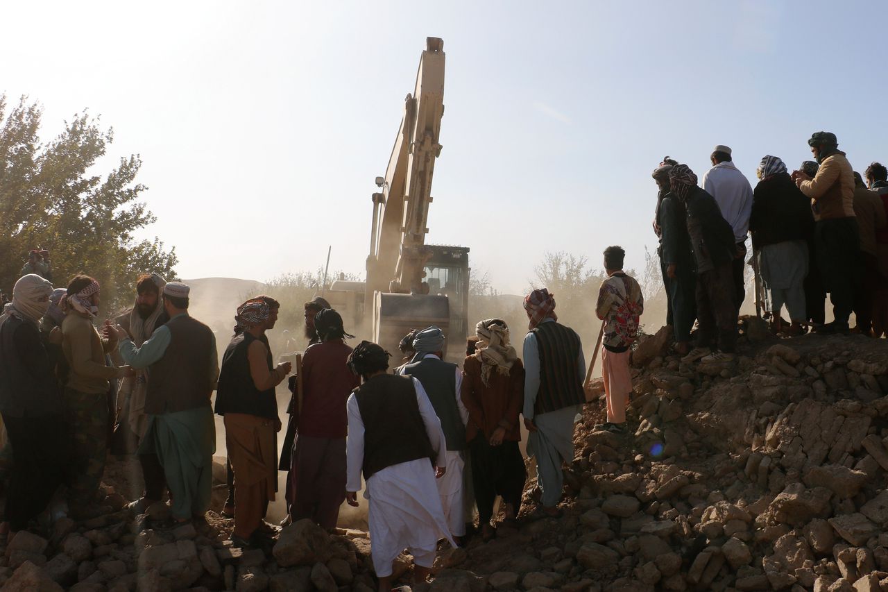 Een graafmachine verwijdert zondag modder uit een ingestort huis na een aardbeving in de provincie Herat, in het westen van Afghanistan.