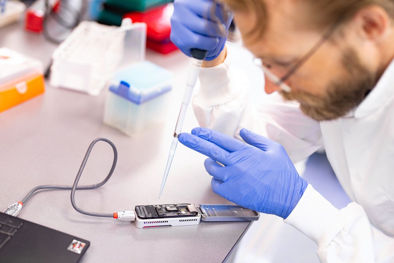 Onderzoeker Carlo Vermeulen druppelt een dna-monster op de nanopore sequencer in het lab in het UMC Utrecht