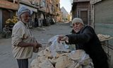 Een man verkoopt brood op straat in Nazlet El-Semman. 