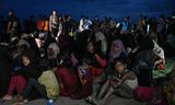 Rohingya-vluchtelingen uit Myanmar wachten woensdag na hun aankomst in de Indonesische provincie Atjeh op vervoer om te worden overgebracht naar onderdak.