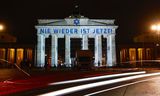 De leus ‘Nooit meer is nu’ wordt op 9 november geprojecteerd op de Brandenburger Tor in Berlijn bij de 85-jarige herdenking van de Kristallnacht. 