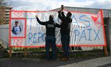 Twee mannen hangen een banner op ter nagedachtenis van de vermoorde Thomas voorafgaand aan een stille mars eerder deze week. De mensen op de foto hebben niets te maken met de extreem-rechtse protesten.