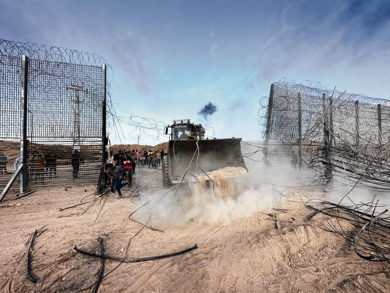 Hamas-militanten verplaatsen zich per shovel door het geforceerde grenshek tussen Gaza en Israël.