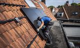 Op dak van een huis in het Groningse Haren worden zonnepanelen geplaatst. De subsidie voor zonnestroom staat al jaren ter discussie. 