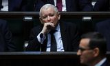 Jaroslaw Kaczynski, al jaren de de facto leider in Polen, luistert naar partijgenoot en premier Mateusz Morawiecki, maandag in het Poolse parlement in Warschau. 