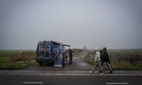 Asielzoekers lopen langs een camper van een hulporganisatie nabij het aanmeldcentrum in Ter Apel. Volgens de Inspectie wordt de maximale bezetting van de opvang „met honderden” overschreden. 