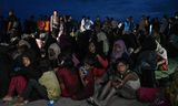 Rohingya-vluchtelingen uit Myanmar wachten woensdag na hun aankomst in de Indonesische provincie Atjeh op vervoer om te worden overgebracht naar onderdak.