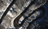 TOPSHOT - This aerial view taken on January 9, 2024, shows a plow clears snow off from the road leading to the Mourtis ski resort in the Pyrenees mountains, southwestern France.