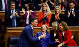 De Spaanse premier Pedro Sánchez, die is gekozen voor een tweede termijn, viert de uitslag van de stemming met politieke medestanders, donderdag in het parlement in Madrid. 