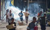 Mensen nemen koopwaar mee uit geplunderde winkels na grote protesten in Port Moresby, de hoofdstad van Papoea-Nieuw-Guinea.